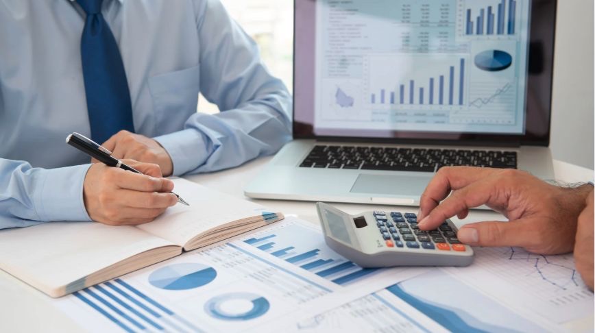 Profesionales analizando gráficas financieras y documentación contributiva